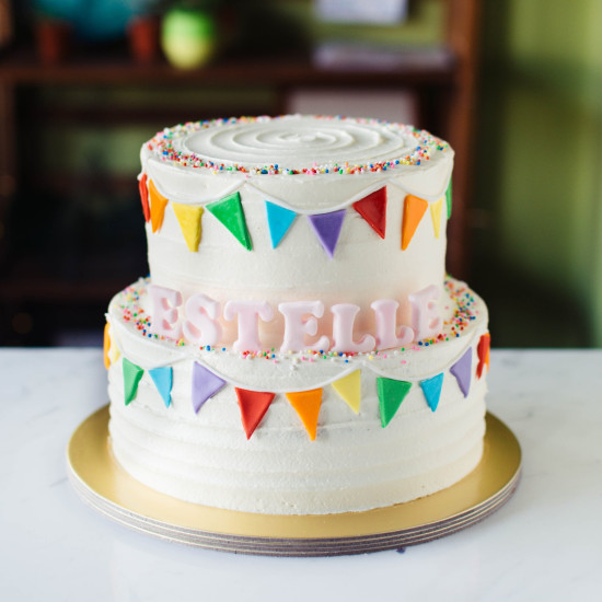 Two Tier White Striped Cake with Fondant Rainbow Bunting